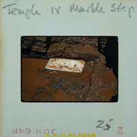Marble step in muddy floor of building interior.