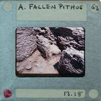 A photograph of a fallen pithos, which is an ancient Greek storage jar, displayed on a card with a description and date stamp.
