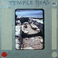 Parallel wall with surface between them and water in the background.