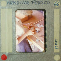 A person working on a craft project with various materials and tools around them.