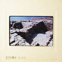 The photo shows an ancient stone structure, possibly a temple or shrine, with a clear sky above.