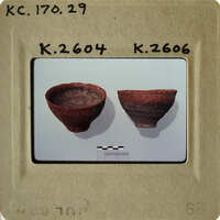 Two clay pots on display, possibly from an archaeological site.