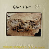 The photo shows an ancient archaeological site with stone ruins and dirt.