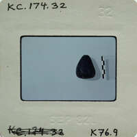 Small black rock on a white surface..