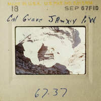 This is an image of a vintage photograph placed on a display card, featuring a rock formation with a caption that reads "Cist Gave Janyx WW".