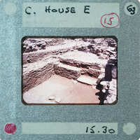 Excavated stone walls with a doorway on right.