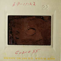 The photograph shows an old slide with a brownish-red substance, possibly soil or mud, and some writing on it.