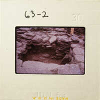 Ancient ruins with exposed stone foundations and walls, possibly part of an archaeological site.