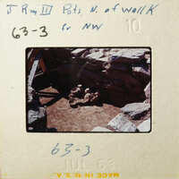 This is an old photograph showing a stone structure with a dirt floor, possibly a historical site.