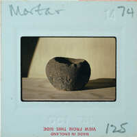 Profile of brown stone bowl on table.