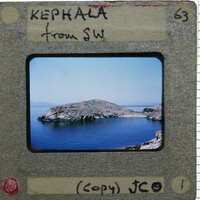 A vintage photograph of a rocky island in the ocean, with handwritten notes on its borders.