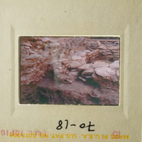 This is a photograph showing an ancient stone structure, possibly a cave or ruins, with a focus on its texture and layers.
