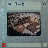 Old photo of a stone structure with a label on it.