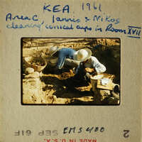 Two men working on a construction project, possibly laying bricks or stones.