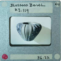 Small ceramic bowl with a rough, textured surface on display, K3.119.