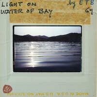 Photo of a serene lake at sunset with mountains in the background, presented as a Polaroid-style image on a white card.