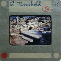 A photo of a stone ruins with a film strip label on it.