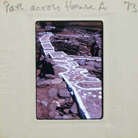 Ancient stone pathway with markings, possibly a Roman road or similar historical site.