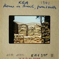 Old photograph of ancient ruins with stone structures and a clear sky.