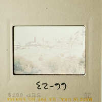 This photo shows an old film strip with a view of a cityscape and a handwritten note on it.