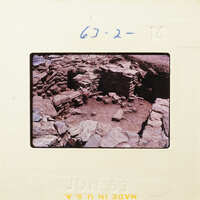 Old ruins with stone walls and dirt ground.