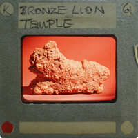 A film clapperboard with a picture of an artifact labeled "BRONZE LION TEMPLE".