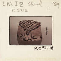 This is a photograph of an object with intricate patterns on it, taken from above and placed against a light background.