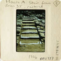 Old stone steps with worn treads, taken from an angle looking up.