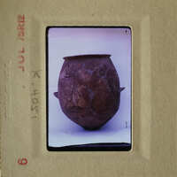 Old, cracked clay pot with visible layers and imperfections.