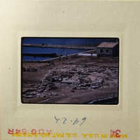 Aerial view of ancient ruins and water body, possibly from an archaeological site.