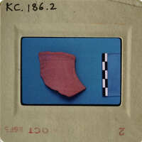 A photograph of an artifact, possibly pottery, with measurement lines and labels indicating its archaeological significance.