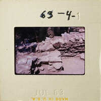 This is an old photograph depicting ruins with stone walls and vegetation, dated July 1983.