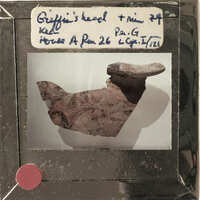 A photograph of a broken clay pot with visible damage and cracks, displayed on a white background.