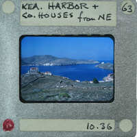 A vintage film strip with a photograph of a coastal landscape featuring houses and the sea.