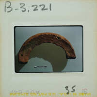 A rusted metal object on display, possibly an artifact or a piece of history.