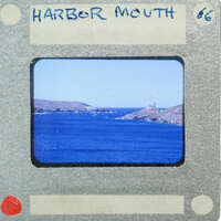 A vintage film strip showing a scenic harbor with blue water and land formations in the background.