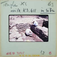 Two people excavating in stone building.