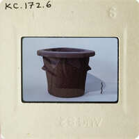 A photograph of an object with a torn edge, possibly a piece of paper or fabric, on a white background.