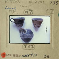 Old broken pottery displayed on a white surface with labels and numbers indicating their identification for study or collection purposes.