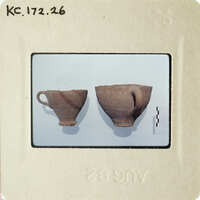 Two ancient pottery cups on display.