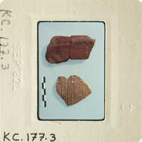 Two ancient pottery shards displayed on a white surface with labels and measurements.
