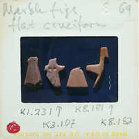 Image of a collection of small marble figurines, possibly ancient artifacts, with labels.
