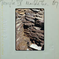 Interior corner of stone wall with water collecting on floor.