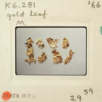 Gold leaf samples displayed on a white surface.