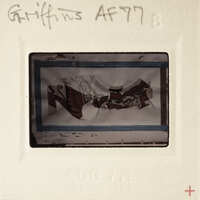 A vintage photograph of a person wearing traditional clothing, possibly from the 19th century, with handwritten annotations on its border.