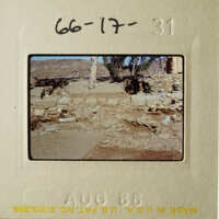 This photo shows an old, worn-out slide with a faded image of a stone wall and a dirt ground, possibly depicting an archaeological site or historical ruins.