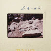 A photograph of an ancient archaeological site with stone ruins and rocks.