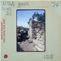 Old stone ruins with trees and a clear sky, captured on an analog film strip.