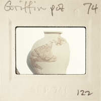 This is an image of a clay pot with a label and number on it, suggesting it's part of a collection or inventory.