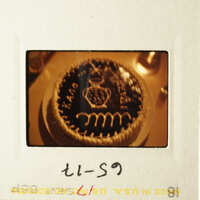 An image of a cake with a coin on top, sitting on a table.